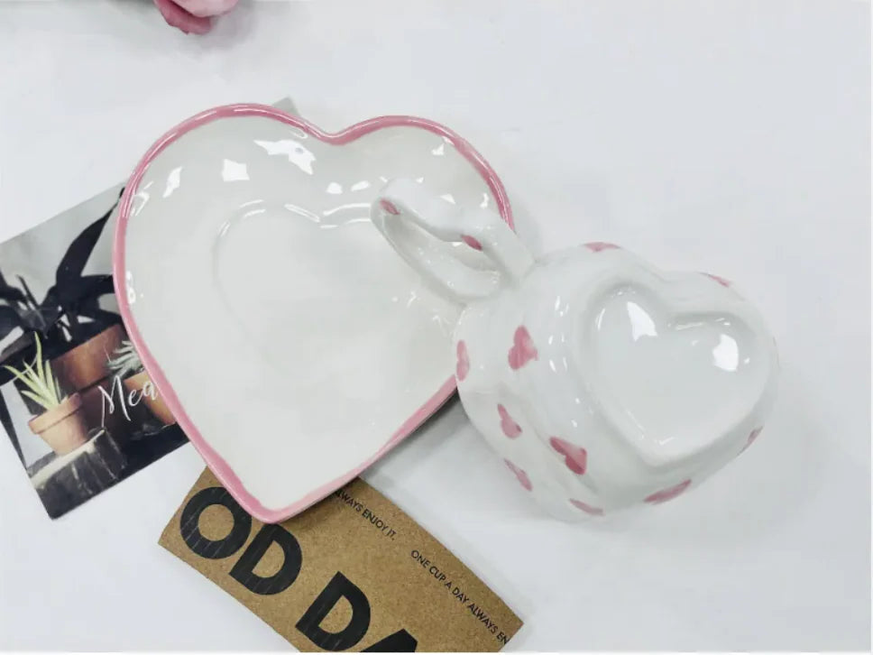 Heart-shaped ceramic dish with pink rim on a white surface